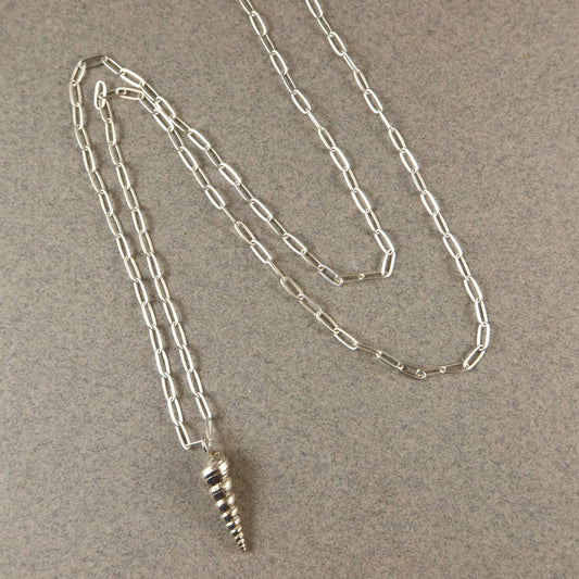 Silver chain necklace with a spiral pendant on a beige background