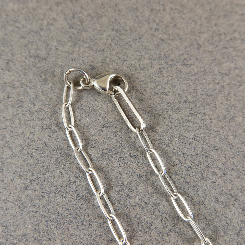 Close-up of a silver chain on a gray surface