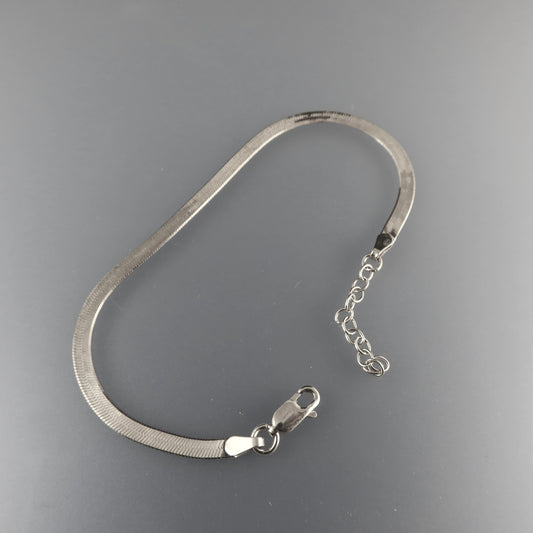 Silver bracelet on a gray background