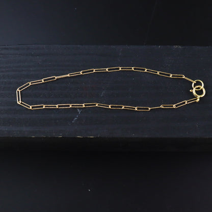 Gold chain necklace on a dark surface