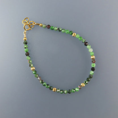 Ruby Beaded bracelet with green and gold accents on a gray background