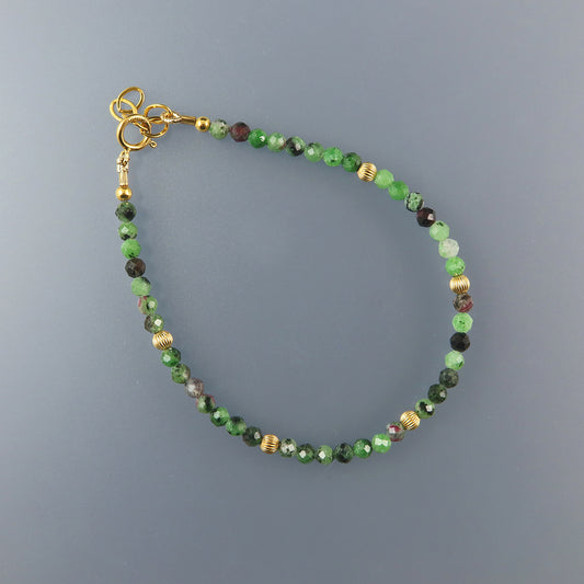 Ruby Beaded bracelet with green and gold accents on a gray background