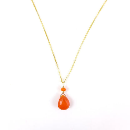 A gold chain necklace featuring a teardrop-shaped orange carnelian pendant