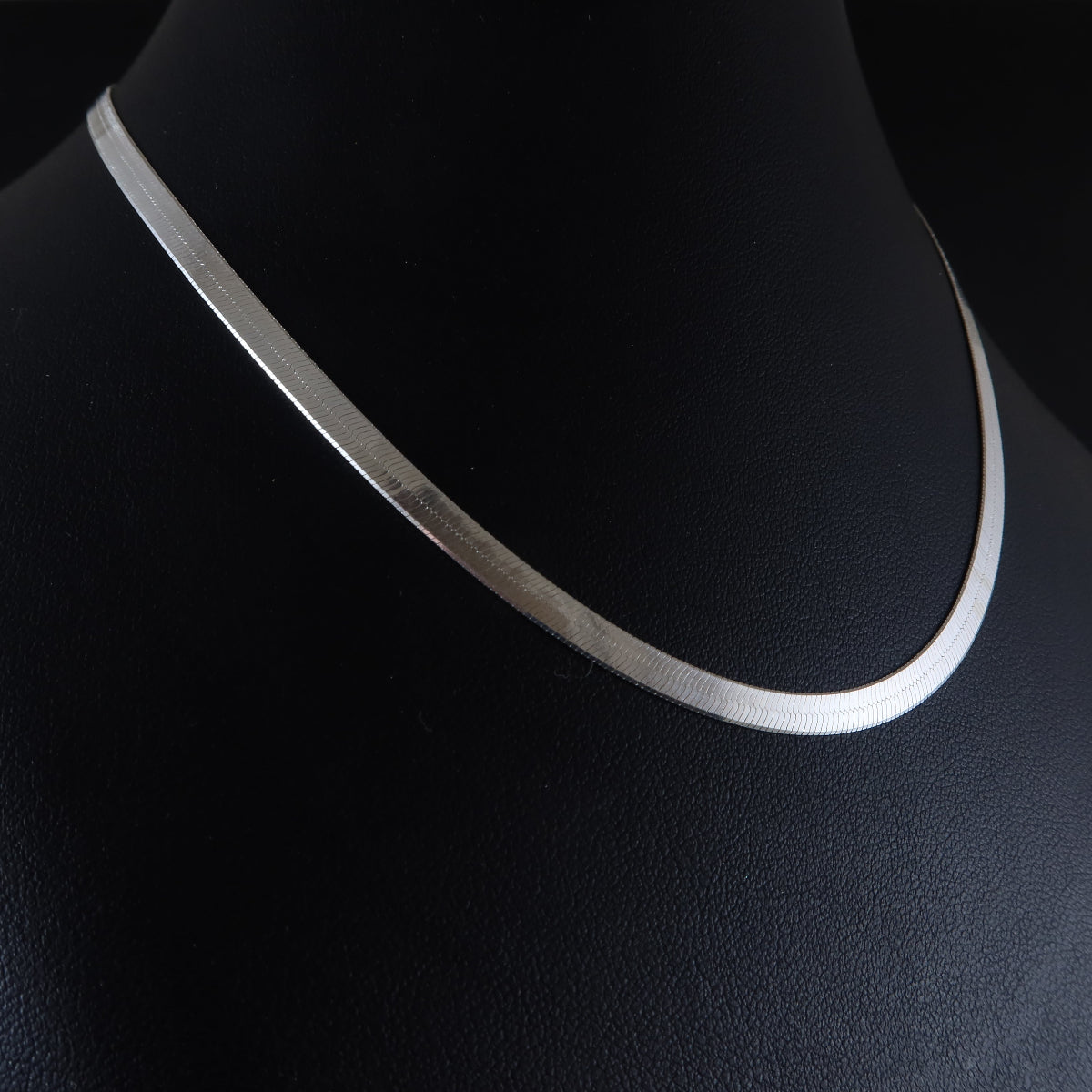 Silver flat chain  necklace on a black mannequin