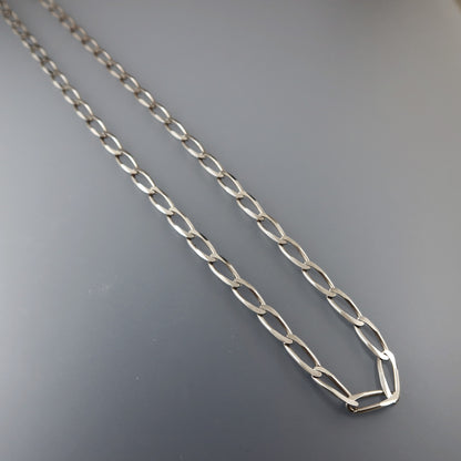 Silver chain necklace on a gray background