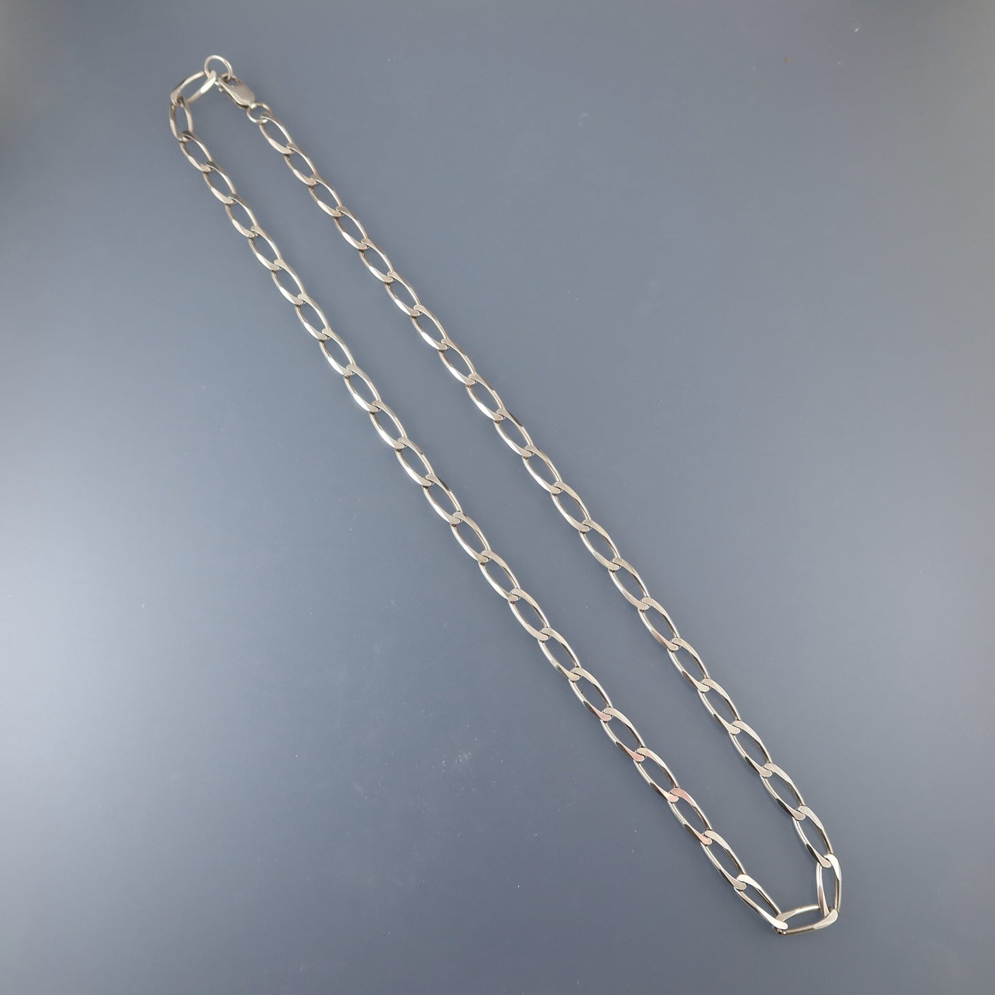 Silver chain necklace on a gray background