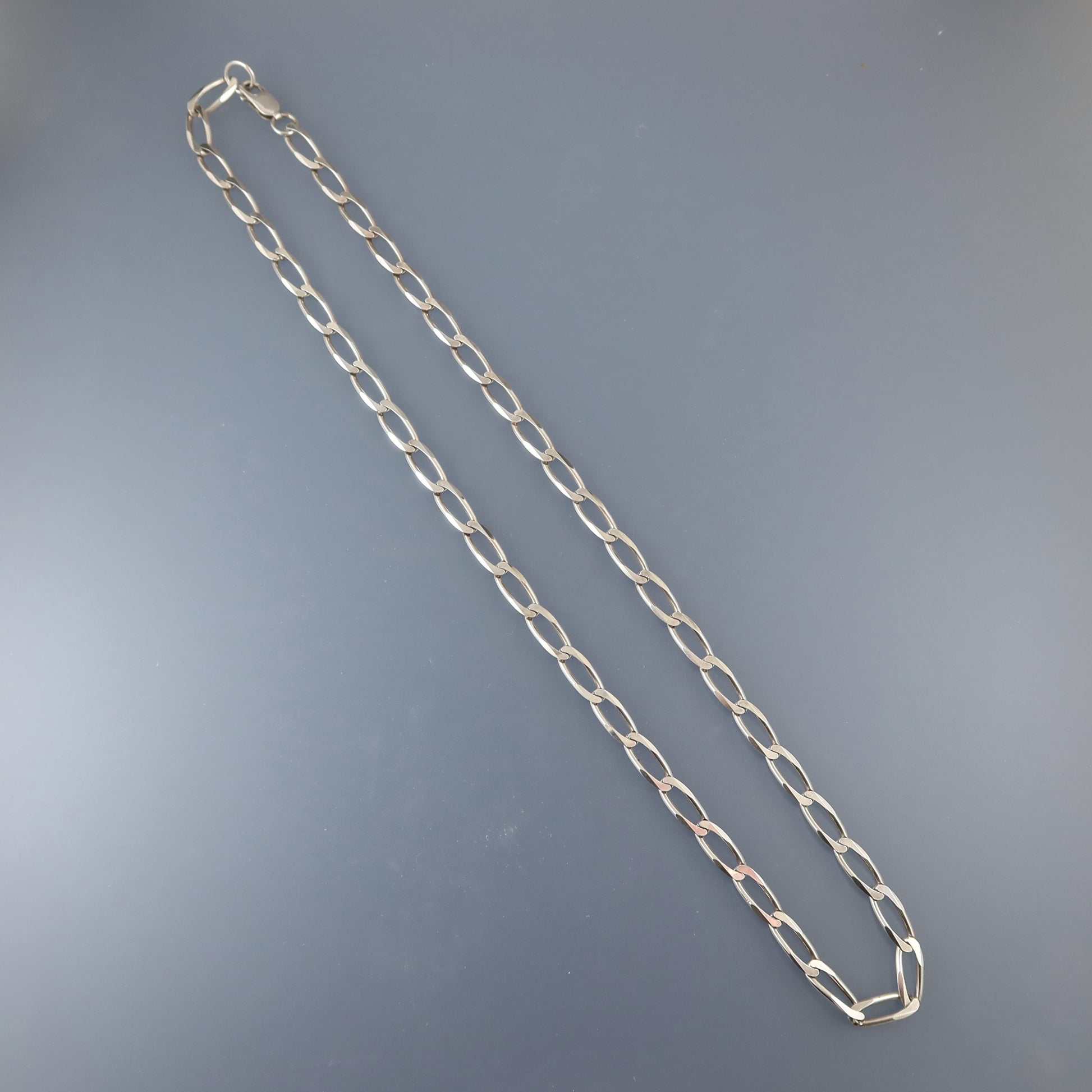 Silver chain necklace on a gray background