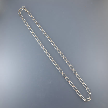 Silver chain necklace on a gray background