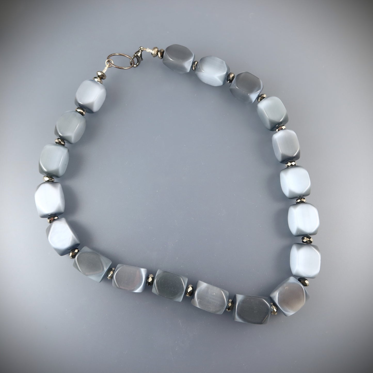 Necklace with light blue beads on a gray background
