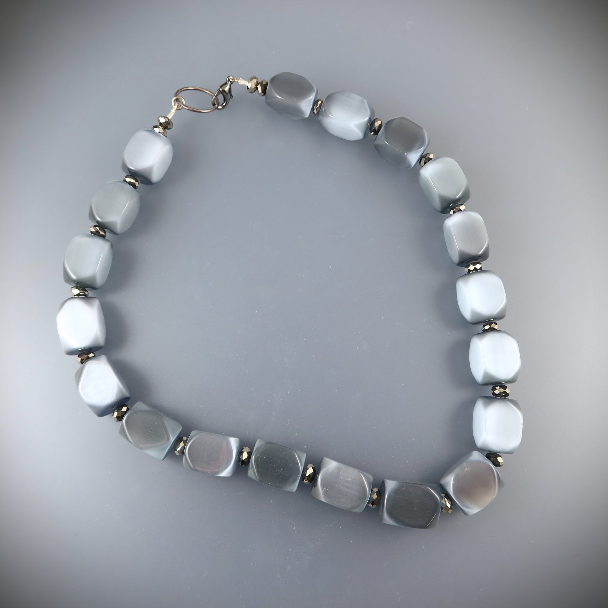 Necklace with light blue beads on a gray background