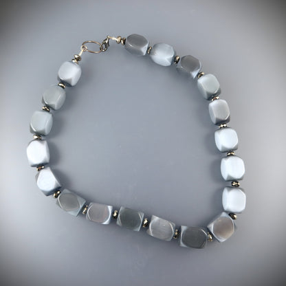 Necklace with light blue beads on a gray background