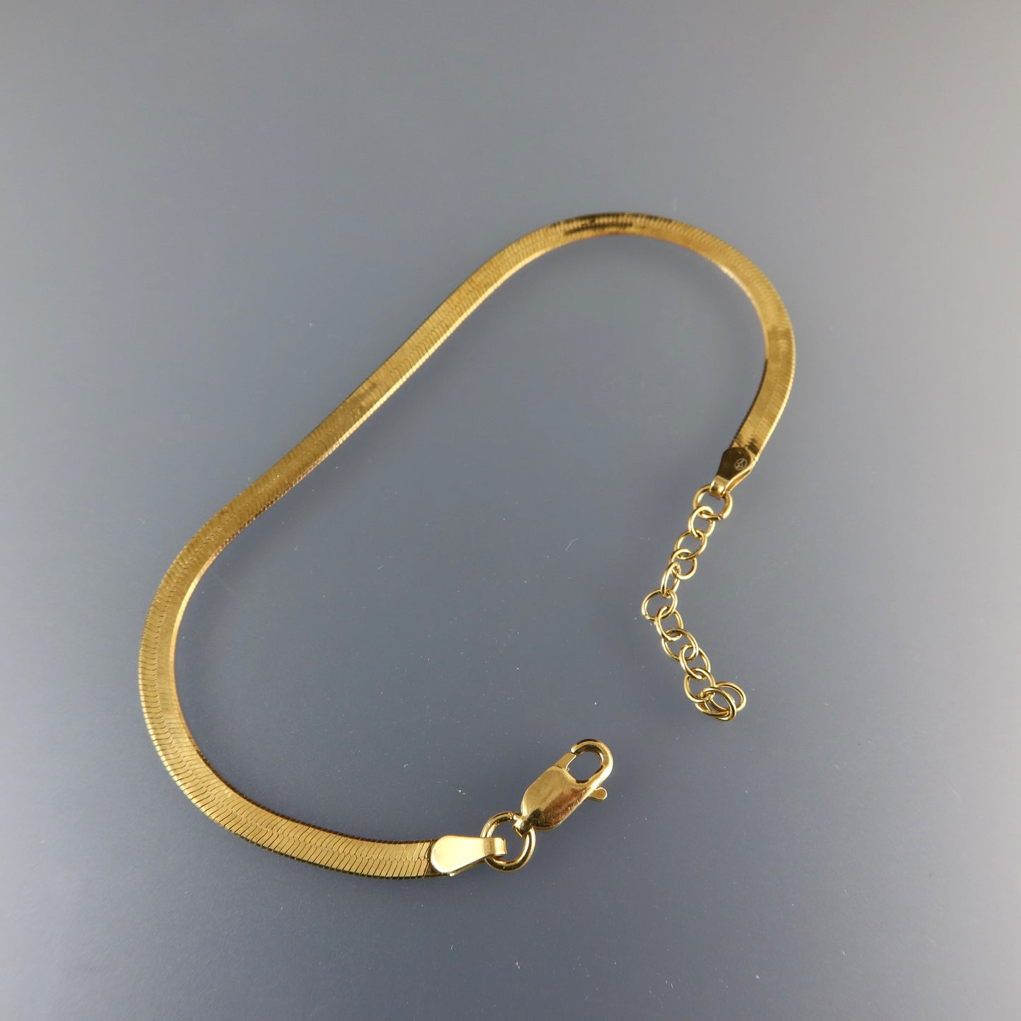 Gold bracelet on a gray background