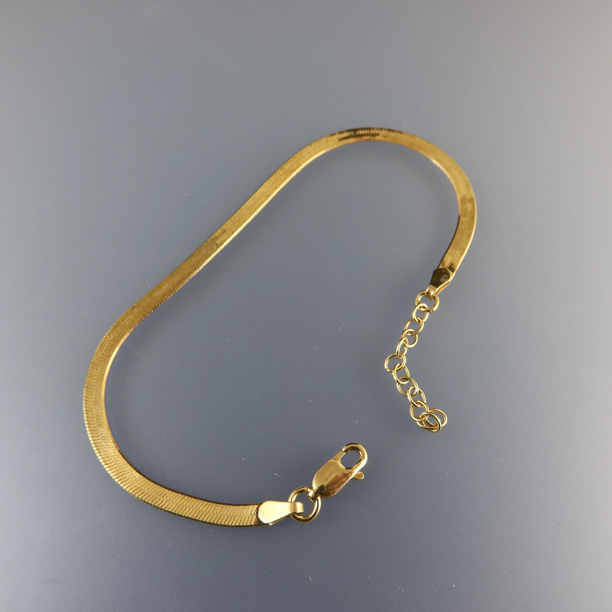 Gold bracelet on a gray background